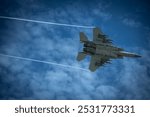 Boeing F-15EX Eagle II fighter jet in flight with beautiful cloudy blue sky background.