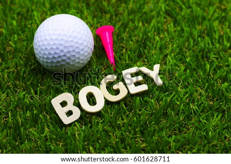 Bogey wording for golfer is on green grass with golf ball and tee.