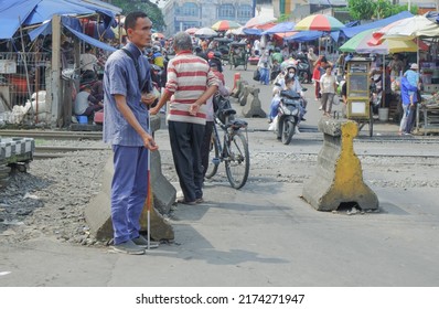 Bogor, Indonesia - July 3rd 2022: A Blind Beggar Who Stands By The Rails To Wish Fortune From People Passing By The Railroad Tracks