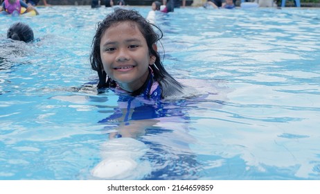 Bogor, Indonesia - May 22nd 2022: Happy Facial Expressions When Children Are Invited To Swim By Their Parents