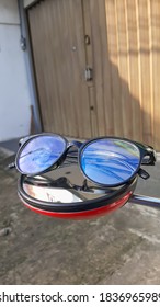 BOGOR, INDONESIA - OCTOBER 20th, 2020 - Black Roxia Brand Glasses On The Rearview Mirror Of The Motorbike