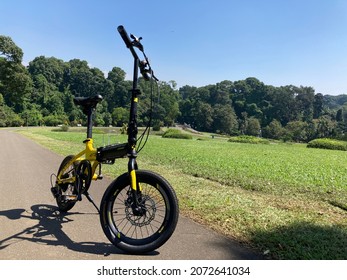 Bogor, Indonesia On April 11, 2021: Black And Yellow Color Folding Bike In A Green Garden.