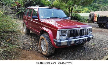 Bogor, Indonesia On Nov 02, 2021: Defocused. Jeep Cherokee Red Color Park In Front Of House Yard. Selective Focus