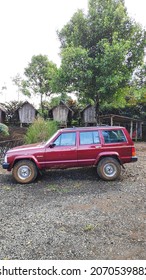 Bogor, Indonesia On Nov 02, 2021: Defocused. Jeep Cherokee Red Color Park In Front Of House Yard. Selective Focus