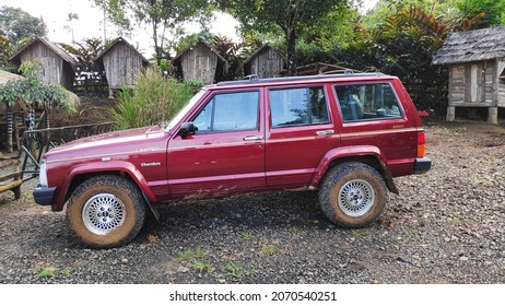 Bogor, Indonesia On Nov 02, 2021: Defocused. Jeep Cherokee Red Color Park In Front Of House Yard. Selective Focus