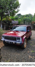 Bogor, Indonesia On Nov 02, 2021: Defocused. Jeep Cherokee Red Color Park In Front Of House Yard. Selective Focus