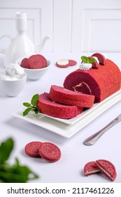 Bogor, West Java, Indonesia-January 24, 2022 : Selective Focus Of Red Velvet Cake Roll Served On White Plate With Oreo Biscuits And Butter Cream On White Table. 