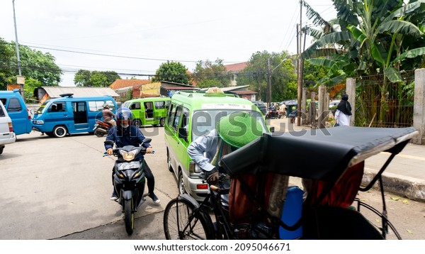 Bogor, West Java - November 12,\
2021 : photo of a pedicab driver working around the Anyar\
market