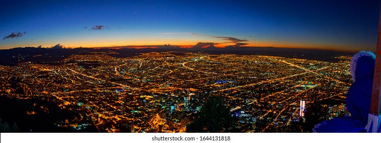 BOGOTA, COLOMBIA - JANURAY 6, 2015: Horizontal Panorama With View Of The City Of Bogota At Dusk From Monserrate, With Night Lights And View Of The Colpatria. Orange And Blue Sky Behind.