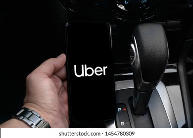 Bogota, Colombia, July 11, 2019, Uber driver holding smartphone in car. Uber is an American company offering transportation services online. Uber APP