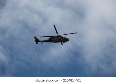 BOGOTA, COLOMBIA - JULY 20 OF 2022 Military Black Hawk Helicopter Flying Over Crow During Colombian Independence Day With Blue Sky