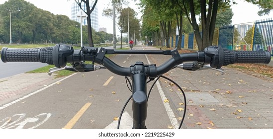 BOGOTA, COLOMBIA - OCTOBER 20 OF 2022 First Person View Of A Mountain Bicycle Handgrip And A Bike Path During Bogota No Car Day Event