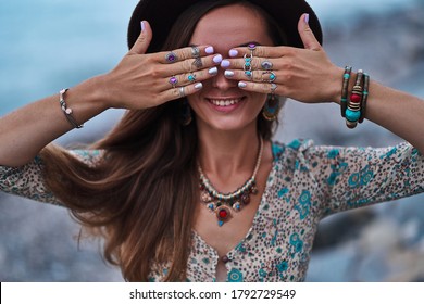 Bohemian chic gypsy smiling happy free woman with manicure wearing hands jewelry accessories, felt hat and dress. Boho detail close up