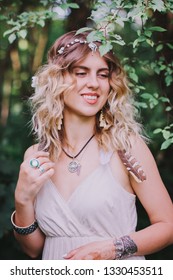 Bohemian Hippie Girl In White Dress.
Woman Hands With Lot Of Boho Style Jewelry, Blue Rings,silver Bracelets And Henna Tattoo.  Coachella Fashion Style Look, Outfit.