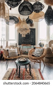 Bohemian Living Room With Ethnic Interior Design. Vertical View Of Hygge House With Home Decor, Natural Material Furniture, Wicker Armchair With Cushions And Wooden Coffee Table