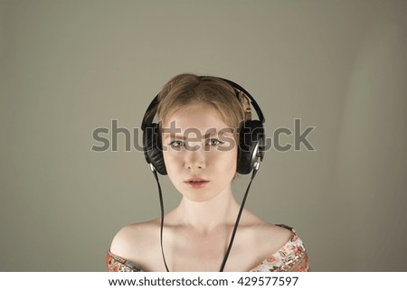 Similar – Young blonde woman listening to music with her headphones