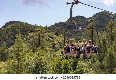 Bohinj, Slovenia - August, 2021: A picture of a family on a ski lift at the Vogel ski resort.