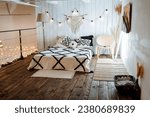 Boho bedroom interior, bed on the second floor of the apartment, white blanket, romantic atmosphere, evening light. High quality photo