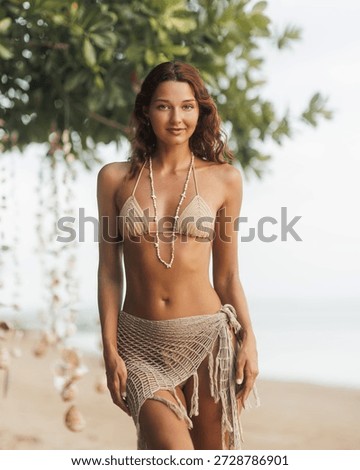 Boho bikini model standing seaside in crochet wrap skirt and shell necklace, framed by tropical tree and soft bokeh. Ideal for resort wear ads, summer travel, wellness and skincare branding campaigns