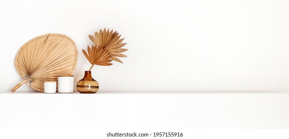 Boho coastal style decoration, a vase, dried palm leaf isolated on a white background wall