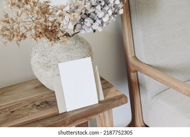 Boho Fall Still Life Photo. Rustic Vase With Dry Hydrangea Flowerss In Ceramic Vase. Blank Horizontal Greeting Card Mockup On Old Wooden Bench. Blurred Linen Sofa Background. Scandinavian Interior.