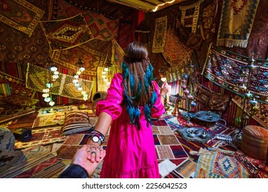 Boho girl traveler vacations at beautiful destination in Goreme, Nevsehir. Follow me to room with traditional Turkish carpets in Kapadokya, Anatolia