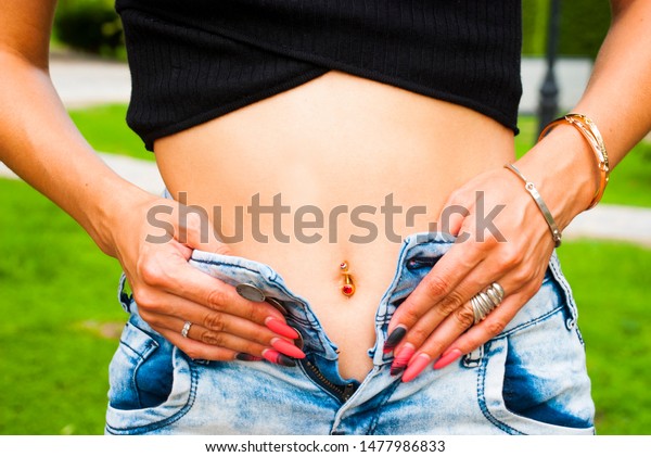 Boho style foto with open belly woman and\
jewelry. Belly with\
piercing.