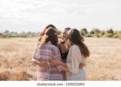 Boho women hugging in rural field