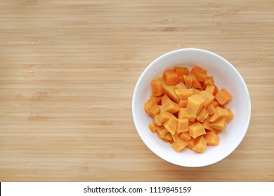 Boil chopped sweet potatoes in white bowl against wooden board background with copy space. - Powered by Shutterstock