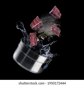 Boil The Pork Bone With Spices And Rosemary And Pepper Into A Pot With Splash Of Water On Black Background,Pork Bone Soup