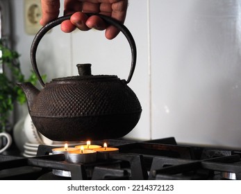 Boil Water In A Kettle On Tea Lights Instead Of Gas In A Stove Burner. Gas Cooker In The Kitchen Of A European Home. Life Hacks For Life Without The Use Of Butane Due To High Cost. Sanctions.