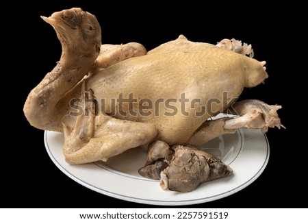 Boiled chicken in a plate for paying homage to gods and ancestors, isolated on a black background.no focus