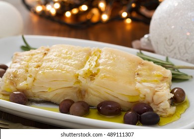 Boiled Cod Fish With Oil And Olives On White Dish