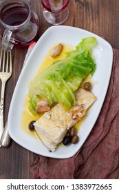 boiled cod fish with olive oil and vegetables on white plate