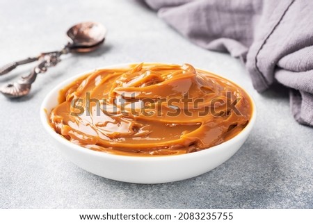 Boiled condensed milk in a plate. Sweet pasta spread for Breakfast and dessert. Copy space
