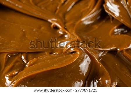 Boiled condensed milk texture or dulce de leche background.