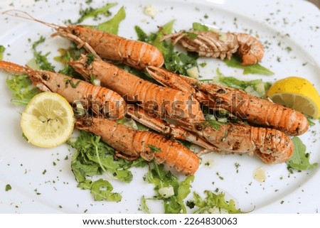 Boiled crawfish with lemon and herbs. Close up.