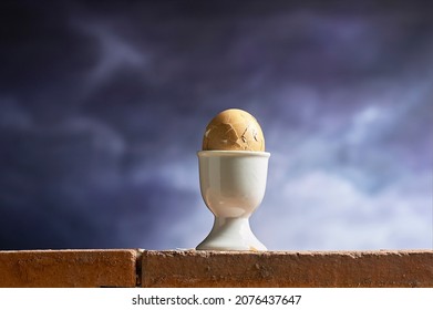 Boiled Egg In Egg Cup Holder With Smashed Shell Positioned On Top Of Brick Wall Like Humpty Dumpty.