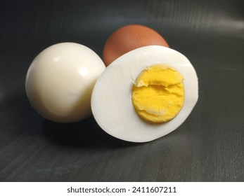 Boiled egg halved and whole egg on black background. Telur rebus - Powered by Shutterstock