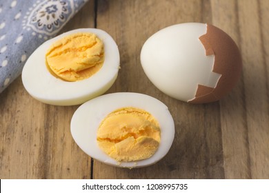 Boiled egg isolated on rustic wooden table - selective focus on hardboiled egg slice