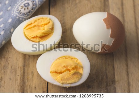 Boiled egg isolated on rustic wooden table - selective focus on hardboiled egg slice
