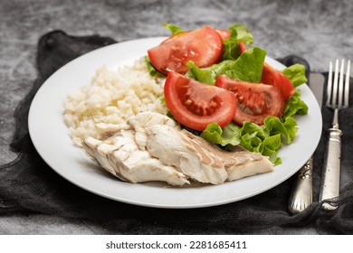 boiled fresh fish with boiled rice and fresh salad on dish