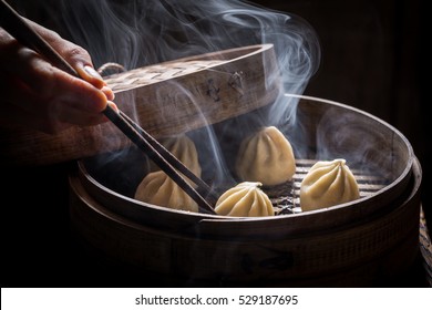 Boiled and hot chinese dumplings in wooden steamer - Shutterstock ID 529187695