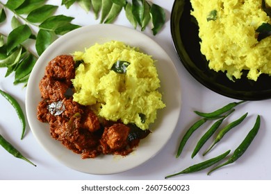 Boiled and mashed tapioca served with rich and spicy chicken curry, infused with aromatic spices. Captured at an angle to emphasize texture and color. Ideal for food blogs, restaurant menus