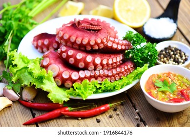 gekochte Tintenfisch-Tentakel, Tintenfisch-Essen auf Holzbrett-Hintergrund, gekochter Tintenfisch-Salat-Chilisauce Meeresfrüchte-Tintenfisch-Dinner-Restaurant
