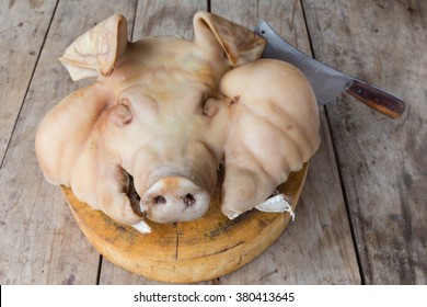 Boiled pig head on block with Knife wood Floor