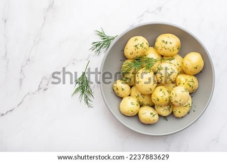 Boiled potatoes with dill on a gray background