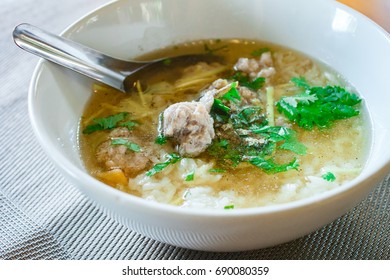 Boiled rice with pork in white bowl, popular breakfast in thai. - Shutterstock ID 690080359