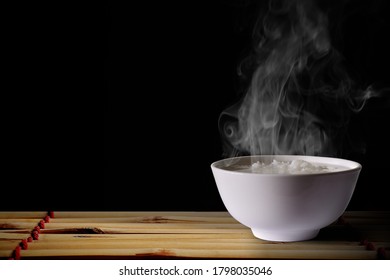 gekochter Reis auf weißem Hintergrund und Rauch auf Bambus-schwarzem Hintergrund  