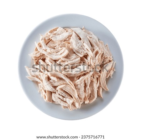 Boiled shredded chicken meat in a plate isolated on a white background. Top view. Chicken fillet meat for consumption, top view.